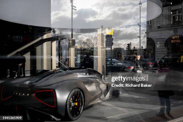 Pedestrians pass-by a Lotus all-electric Evija sports car which is positioned in the window of the British motoring brand's showroom on Piccadilly,...