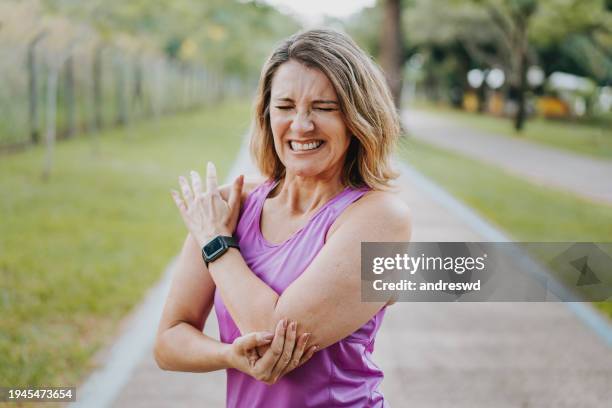 portrait of mature woman with elbow pain - elbow stock pictures, royalty-free photos & images