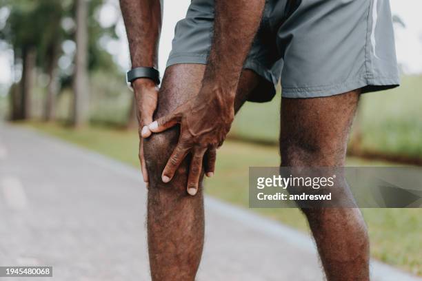 with hands on knee pain - hugging knees stock pictures, royalty-free photos & images