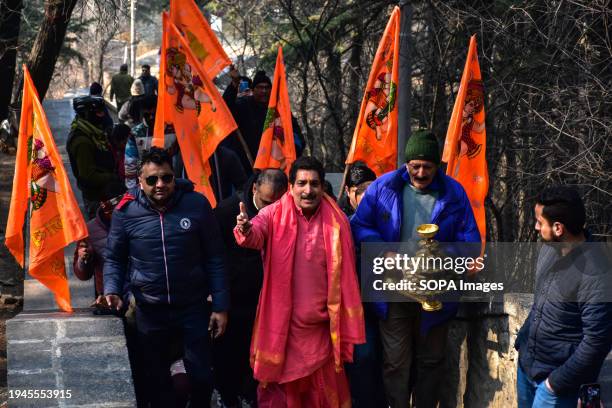 Hindu devotees shout religious slogans as they arrive to perform rituals at the Shankaracharya temple on the occasion of Ayodhya Ram temple's...