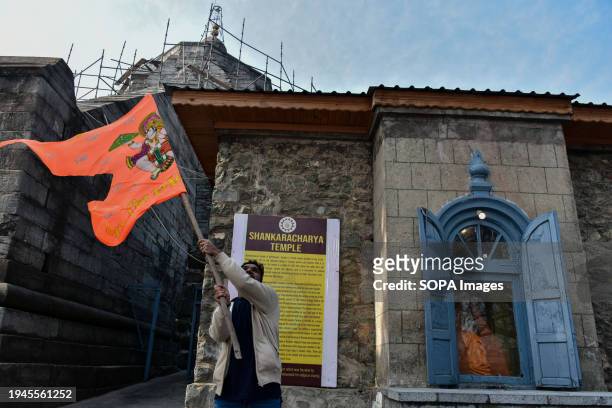 Hindu devotee holds a religious flag at the Shankaracharya temple on the occasion of Ayodhya Ram temple's consecration ceremony. Prime Minister...
