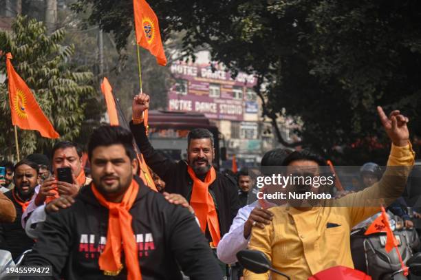 People are chanting slogans and waving flags with a portrait of the Hindu god Lord Ram during a procession to celebrate the opening of the Hindu Ram...