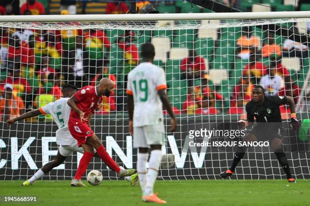 Ivory Coast's goalkeeper Yahia Fofana looks on as Equatorial Guinea's forward Emilio Nsue shoots and scores his team's first goal during the Africa...