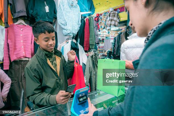 les jeunes effectuent des paiements sans contact. - industrie de la mode photos et images de collection