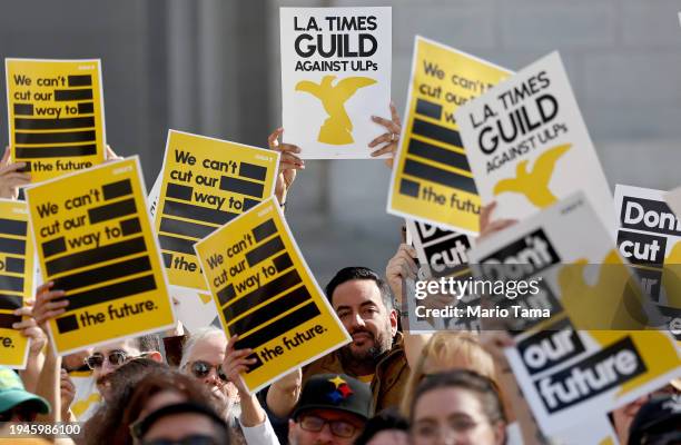 Los Angeles Times Guild members hold up signs during a rally outside City Hall against ‘significant’ imminent layoffs at the Los Angeles Times...