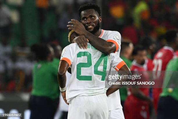 Ivory Coast's forward Simon Adingra is consoled by a teammate after Equatorial Guinea won the Africa Cup of Nations 2024 group A football match...