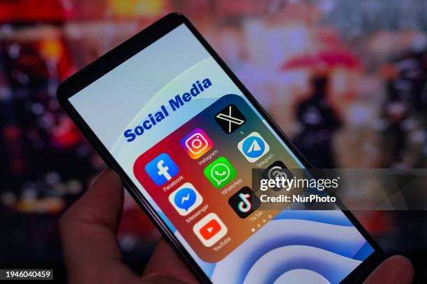 Icons for various social media apps, including Facebook, Instagram, X, Threads, and TikTok, are being displayed on a smartphone in this photo...