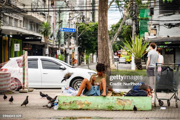 Homeless man is eating on the street in Niteroi, Brazil, on January 21, 2024.