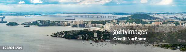 Panoramic view is being seen from the City Park in Niteroi, showcasing the city of Niteroi on the right and the bridge that connects to Rio De...