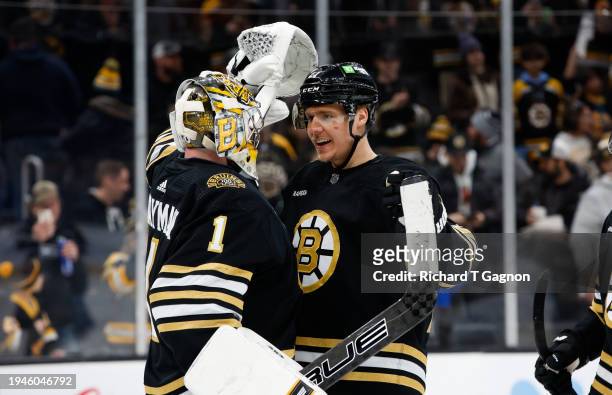 Jeremy Swayman of the Boston Bruins celebrates a victory against the Winnipeg Jets with teammate Hampus Lindholm at the TD Garden on January 22, 2024...