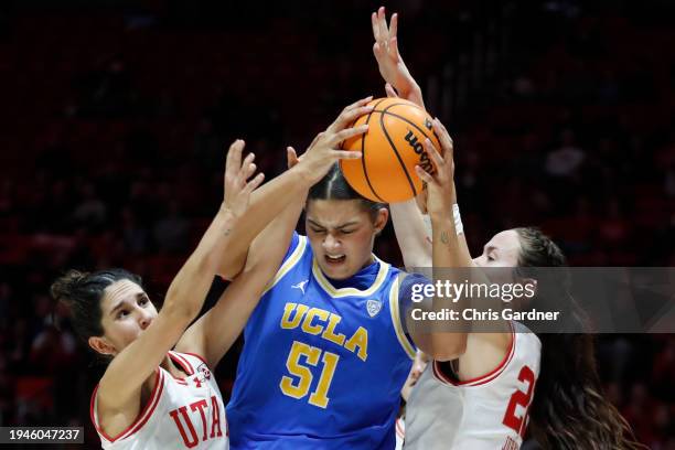 Lauren Betts of the UCLA Bruins is pressured by Ines Vieira and Jenna Johnson of the Utah Utes during the first half of their game at Jon M Huntsman...