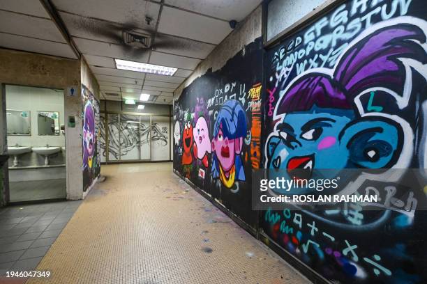 This photograph taken on January 19, 2024 shows murals and graffiti on the walls inside the Peace Centre building in Singapore. In Singapore, where...