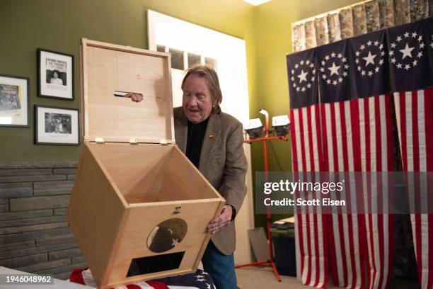 Dixville Town Moderator Tom Tillotson opens the ballot box to show its empty just before midnight on January 22, 2024 in Dixville Notch, New...