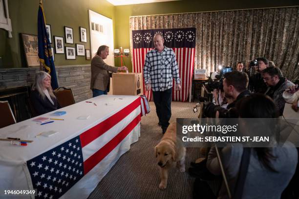 Voter walks with his dog after casting his ballot in the First-in-the-Nation midnight vote for the New Hampshire primary elections in the Living Room...