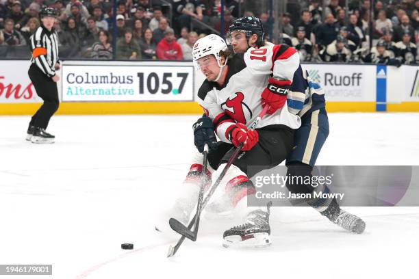 Alexander Holtz of the New Jersey Devils skates with the puck against Jake Bean of the Columbus Blue Jackets during the first period at Nationwide...