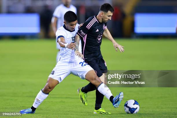 Melvin Cartagena of El Salvador battles for possession with Lionel Messi of Inter Miami FC during a friendly match between El Salvador and Inter...