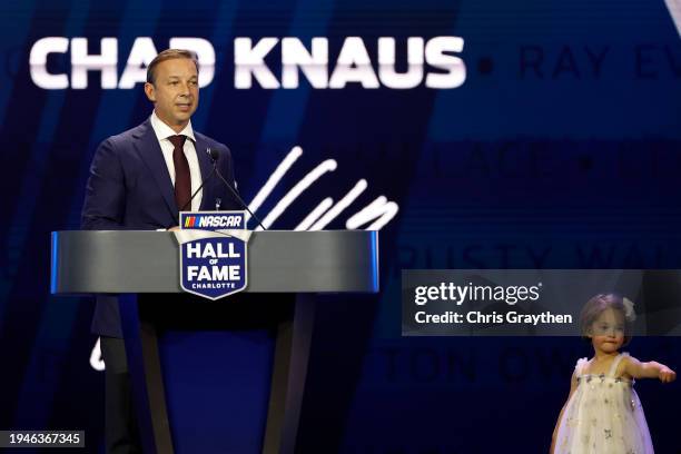 Hall of Fame inductee Chad Knaus speaks as his daughter, Vivienne Mae Knaus looks on during the 2024 NASCAR Hall of Fame Induction Ceremony at...