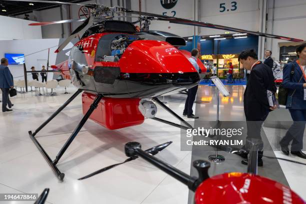 Visitors view an SH-750 rotary wing unmanned aerial vehicle on display at the UMEX Exhibition showcasing drones, robotics, and unmanned sytems at the...