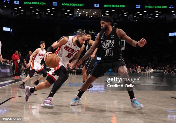 Caleb Martin of the Miami Heat in action against Royce O'Neale of the Brooklyn Nets during their game at Barclays Center on January 15, 2024 in New...