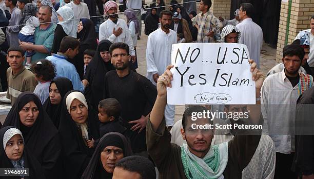 Man holds up an Anti-U.S. Sign April 22, 2003 in Karbala, Iraq. Tens of thousands Iraqi Shiite Muslims converged this week to mark the end of 40 days...