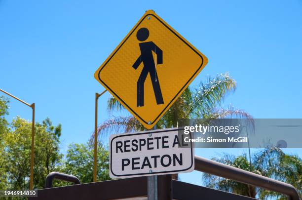 caution pedestrian crossing and spanish-language 'respete al peaton' [respect pedestrians] road warning signs - pedestrian crossing sign stock pictures, royalty-free photos & images