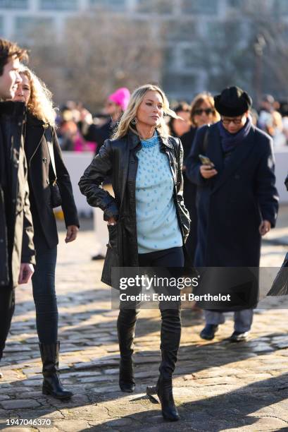 Kate Moss wears a black leather jacket, a blue top with embellishments, black leggings, black thigh high leather boots, outside Dior, during the...