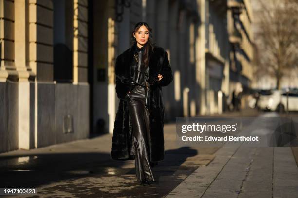 Heart Evangelista wears sunglasses, earrings, a black long fluffy winter faux fur coat, a black leather jacket, black leather flared pants, a...