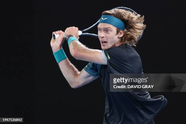 Russia's Andrey Rublev hits a return against Italy's Jannik Sinner during their men's singles quarter-final match on day 10 of the Australian Open...