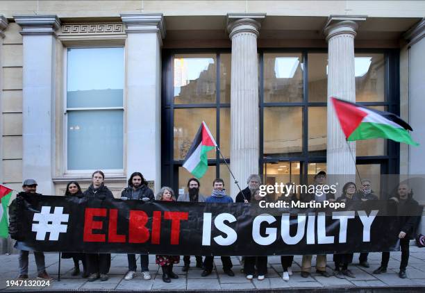 Five of the Elbit Bristol 7 stand outside the crown court with their supporters behind a banner saying Elbit is guilty during their trial on January...