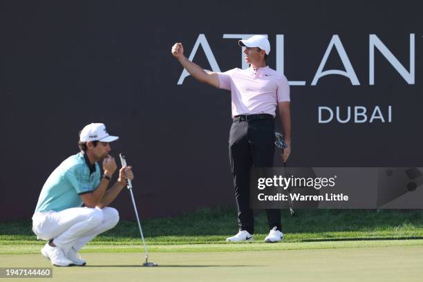 Rory McIlroy of Northern Ireland celebrates after an eagle putt on the 18th green as Joaquin Niemann of Chile looks on during Round Three of the Hero...