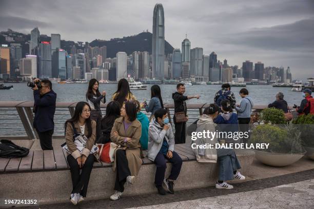 Mainland Chinese tourists visit a promenade next to Victoria Harbour in Hong Kong on January 17, 2024.