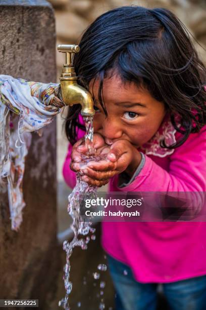 nepalese girl drinking water, upper mustang, nepal - nepal children stock pictures, royalty-free photos & images