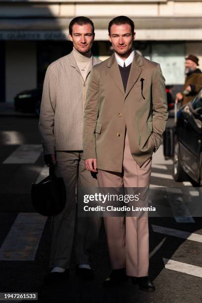 Scott Staniland wears beige turtleneck top, beige checked jacket with matching trousers, and Twins Brett Staniland wears white shirt, brown sweater,...