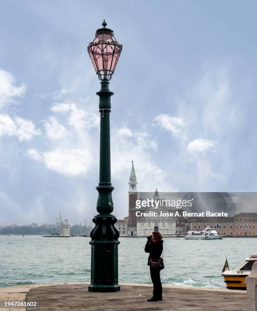 a tourist woman walking and taking photos in the city of venice. - vaporetto stock pictures, royalty-free photos & images