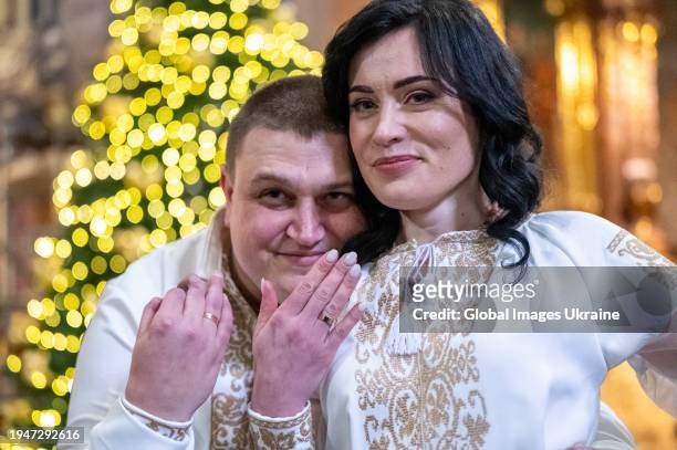 Andriy Odolko and his bride Inna Vasylenko show wedding rings during the wedding ceremony in the Garrison Church on January 19, 2024 in Lviv,...
