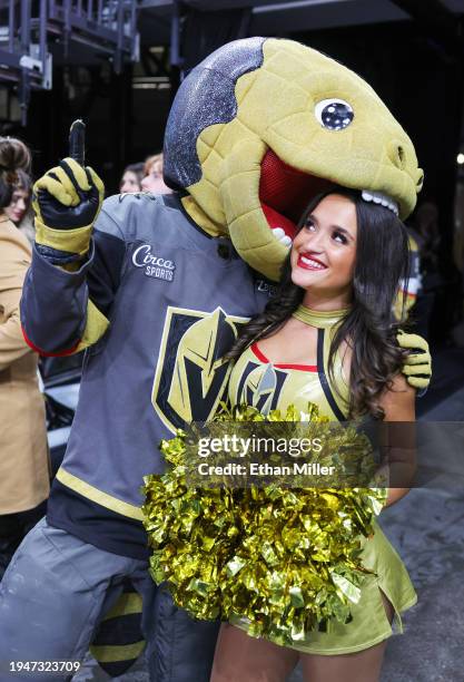 The Vegas Golden Knights mascot Chance the Golden Gila Monster jokes around with a member of the Golden Knights Vegas Vivas cheerleaders after Mark...