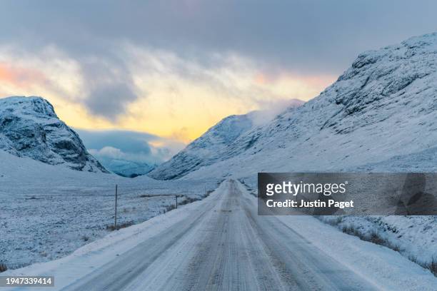 a view of a main road through the scottish highlands after a day of freezing temperatures and heavy snow, creating treacherous driving conditions - landscape stock pictures, royalty-free photos & images