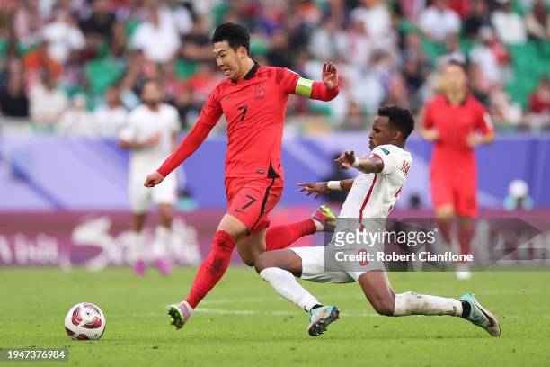 Son Heung-min of South Korea is challenged by Abdallah Nasib of Jordan during the AFC Asian Cup Group E match between Jordan and South Korea at Al...