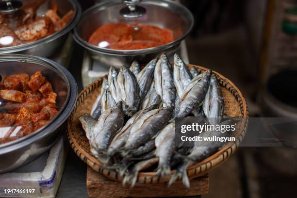 dried freshwater fish selling in bamboo platter - tellerlift stock-fotos und bilder