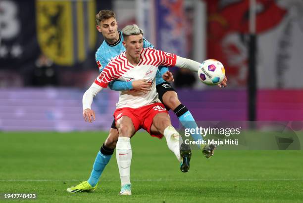 Benjamin Sesko of RB Leipzig is challenged by Josip Stanisic of Bayer Leverkusen during the Bundesliga match between RB Leipzig and Bayer 04...