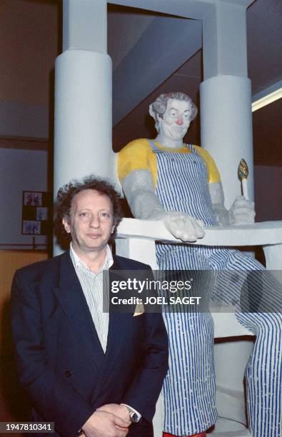 Portrait taken on February 23, 1989 shows French producer Paul Lederman next to a sculpture bearing the image of Coluche at the inauguration of a...