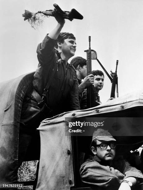 An Armed Forces Movement soldier standing on a military truck, with a flower at the end of his rifle, shows his joy, on April 26, 1974 in Lisbon,...