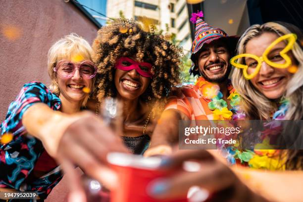 freunde stoßen während der karnevalsfeier zu hause an - karneval stock-fotos und bilder