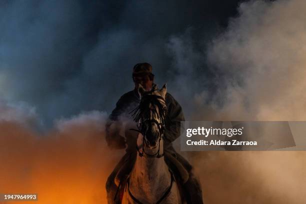 Man rides a horse through bonfires during 'Las Luminarias' Festival on January 16, 2024 in San Bartolome de Pinares, Spain. Each year, horses leap...