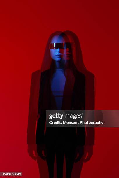 futuristic fashion woman with futuristic sunglasses in red glowing background - dark room stock-fotos und bilder