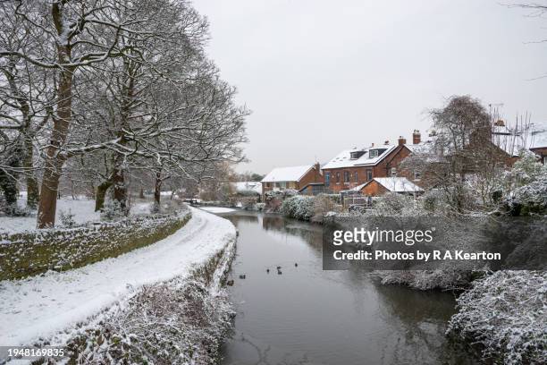 the peak forest canal, marple on a snowy january morning - duck tow path stockfoto's en -beelden