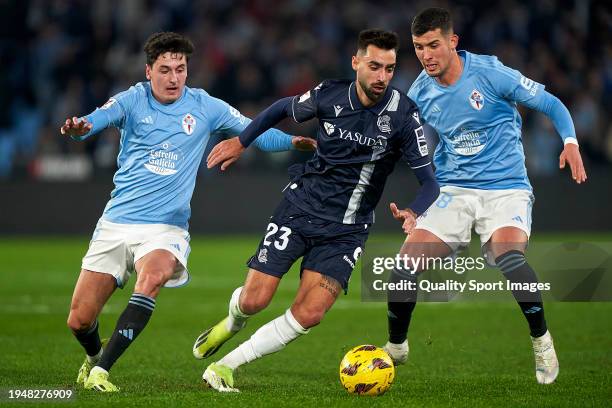 Carlos Dotor and Carlos Dominguez of RC Celta de Vigo compete for the ball with Brais Mendez of Real Sociedad during the LaLiga EA Sports match...