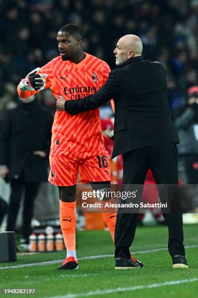 Mike Maignan of AC Milan reacts towards the fourth official alongside Stefano Pioli, Head Coach of AC Milan, during the Serie A TIM match between...