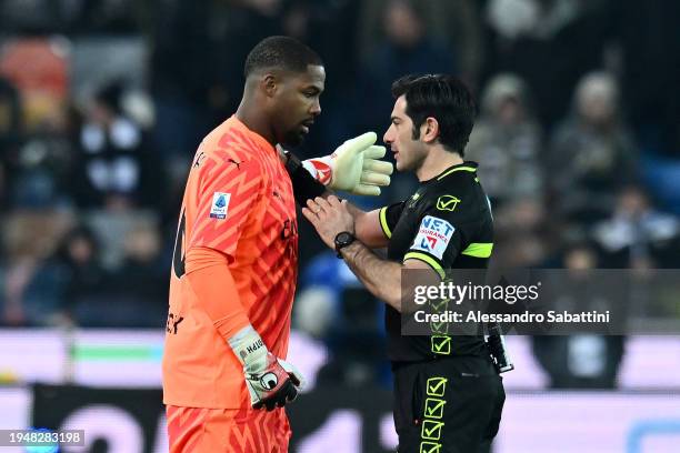 Mike Maignan of AC Milan speaks with referee Fabio Maresca during the Serie A TIM match between Udinese Calcio and AC Milan at Dacia Arena on January...