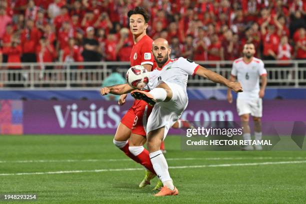 Palestine's midfielder Mohammed Rashid clears the ball during the Qatar 2023 AFC Asian Cup Group C football match between Hong Kong and Palestine at...